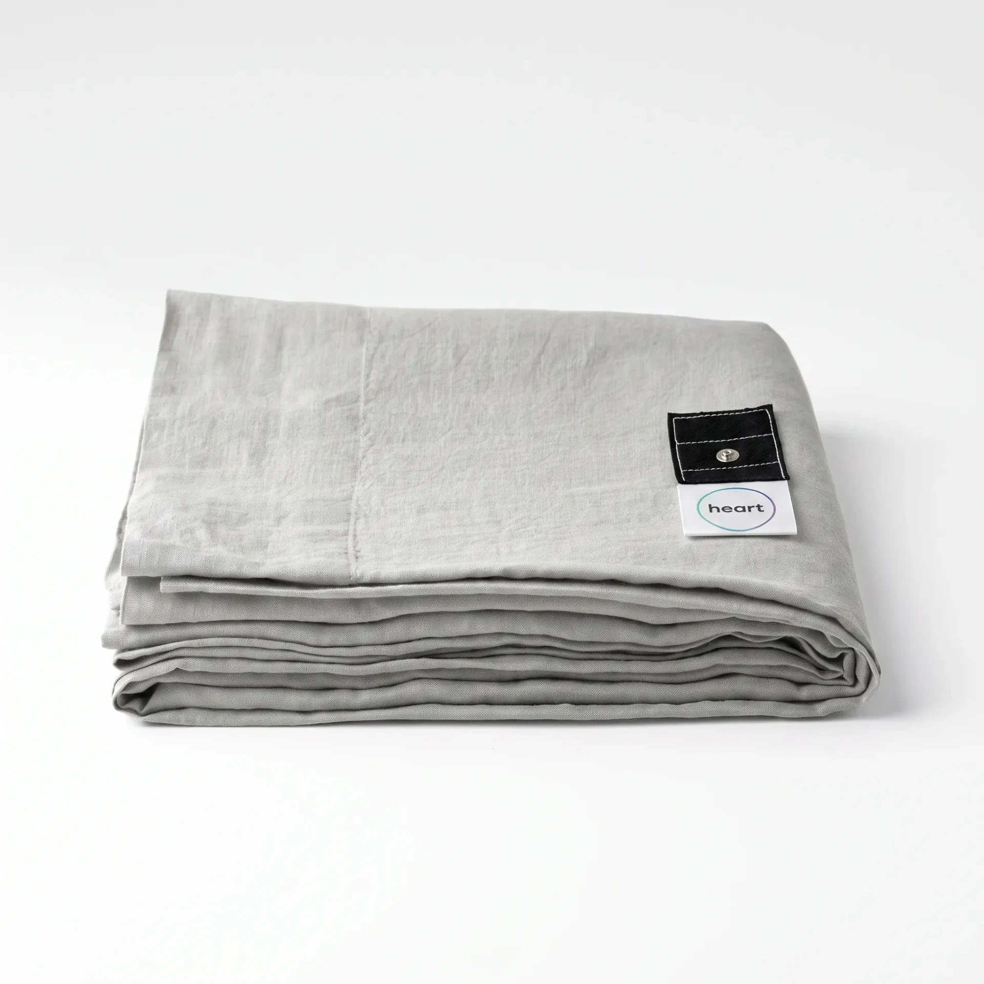 Close view of the light-grey Grounding Heart cotton sheet and connection tab
