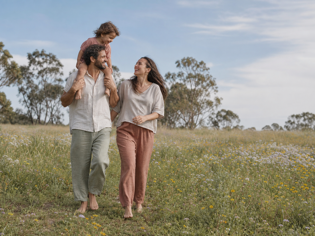 Family walking barefoot together through a grassy field, illustrating a simple everyday way to try earthing