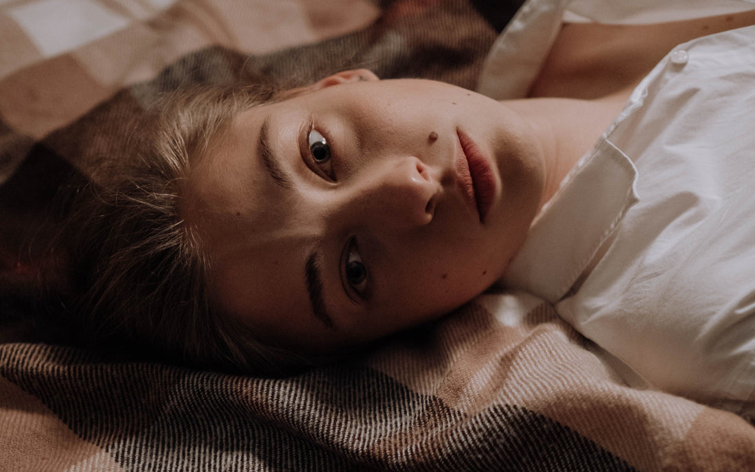 Woman lying in bed, illustrating the article on fact-checking common grounding and earthing safety myths